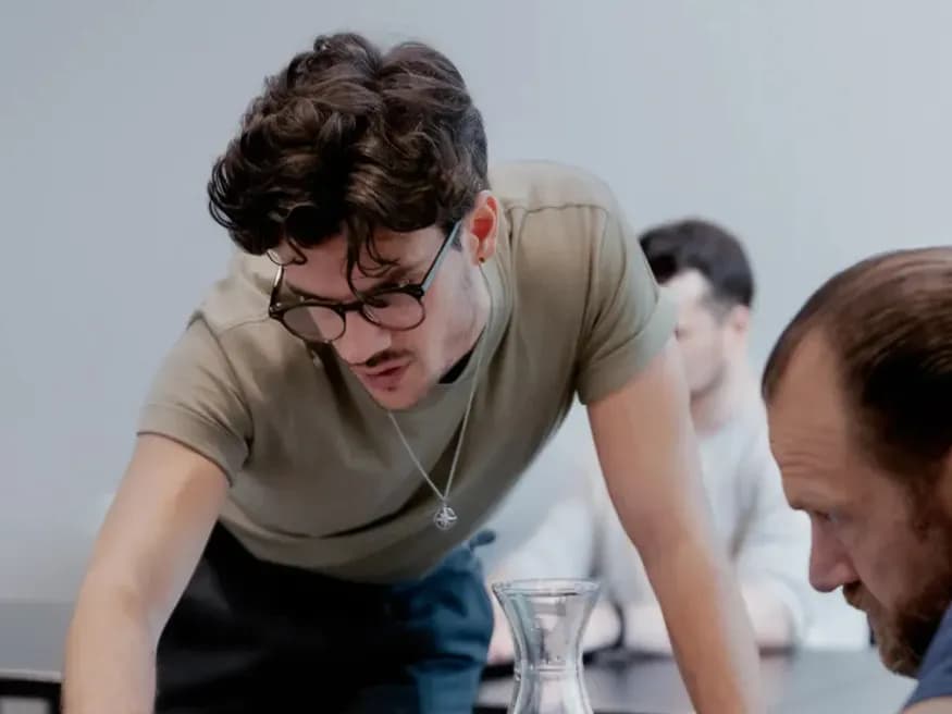 PromptGorillas consultant in gesprek met een klant achter een laptop in een informele setting