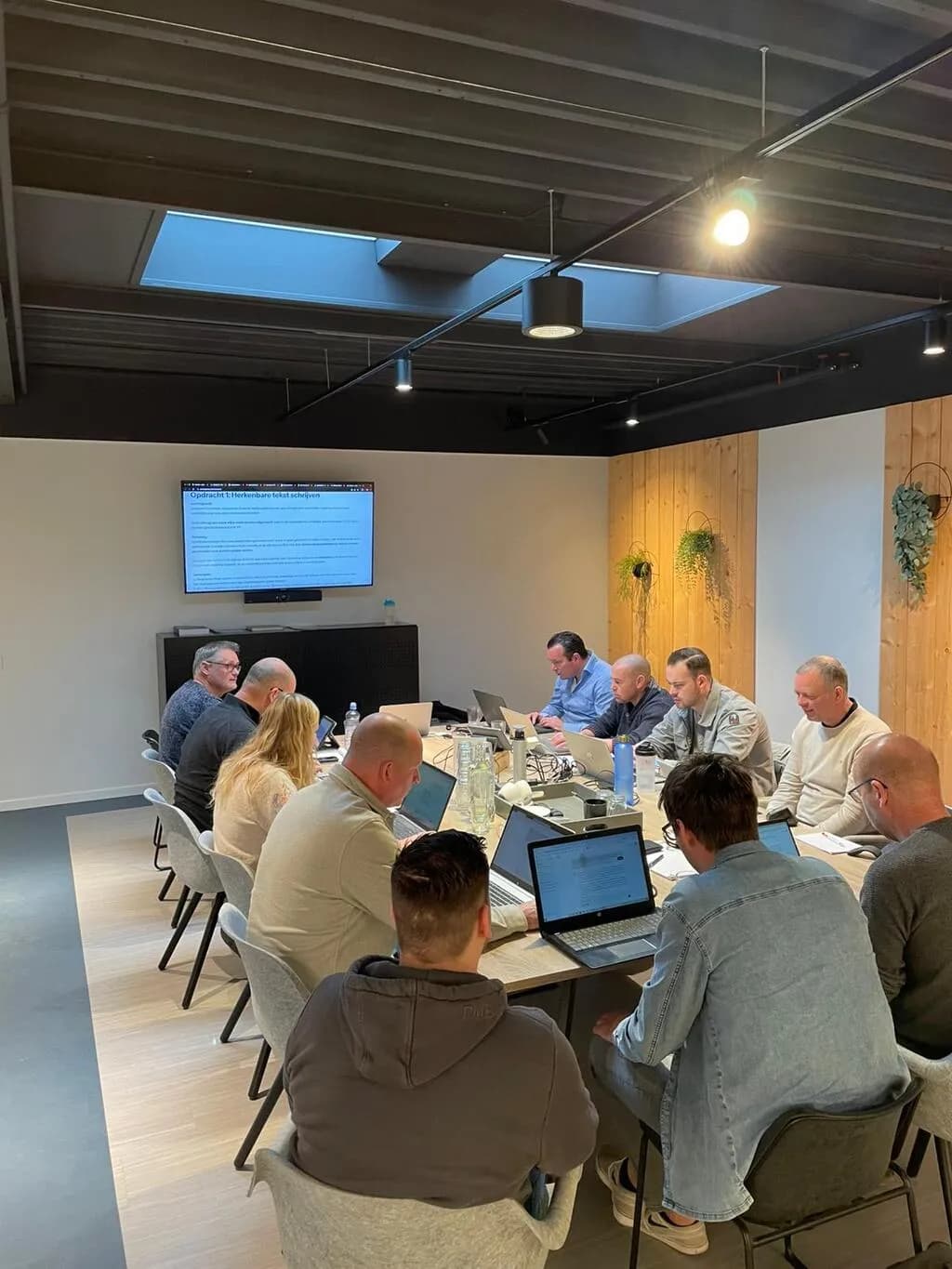 Team van ElektroNed volgt een incompany AI-training met laptops aan een grote vergadertafel