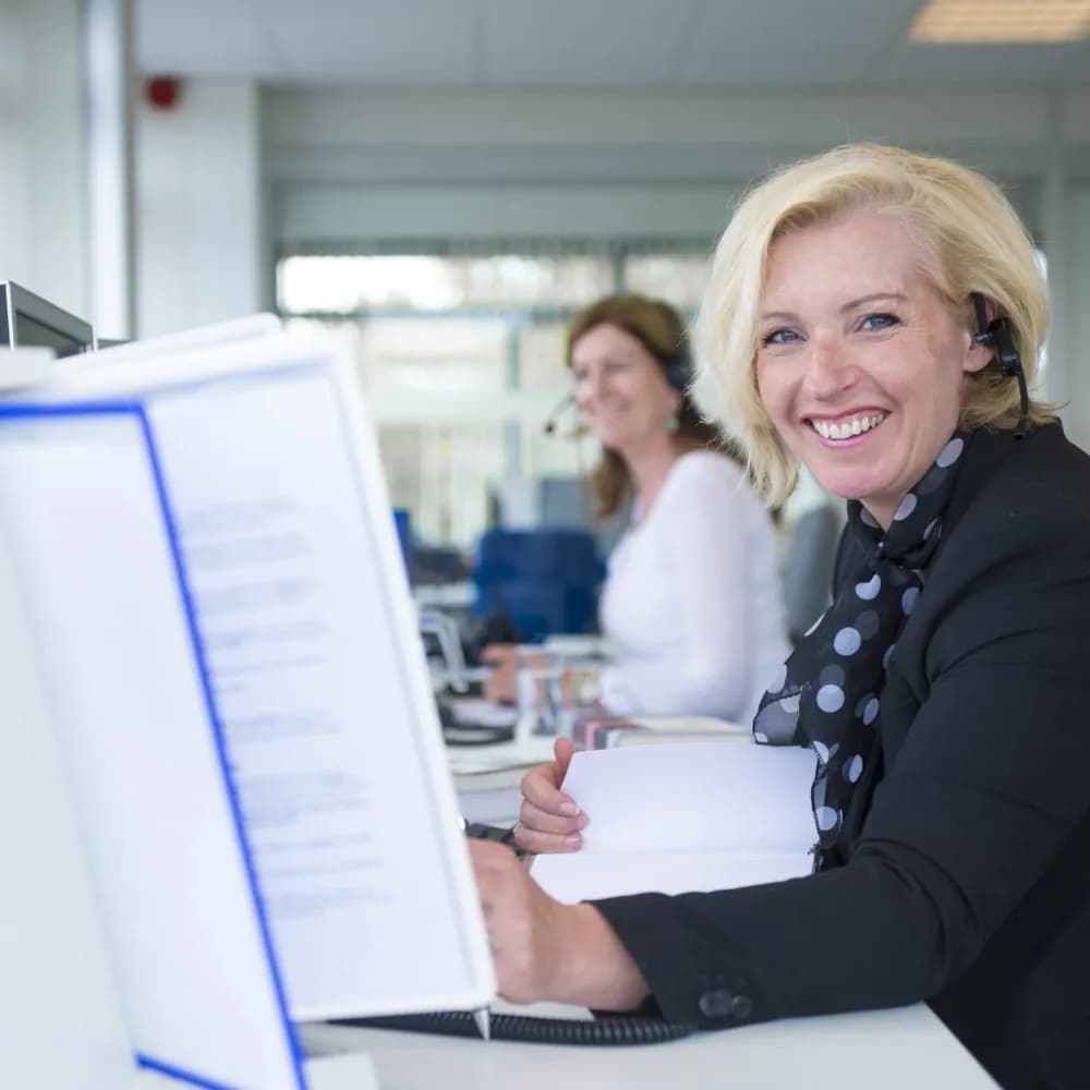 Klantenservice medewerker met headset aan het werk achter een bureau, als beeld bij de AI training en automatisering case