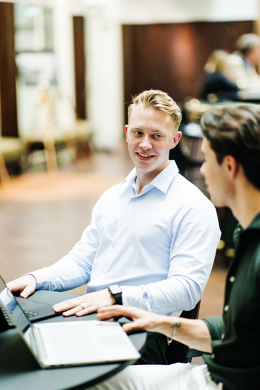 PromptGorillas consultant in een persoonlijk gesprek met een collega achter een laptop
