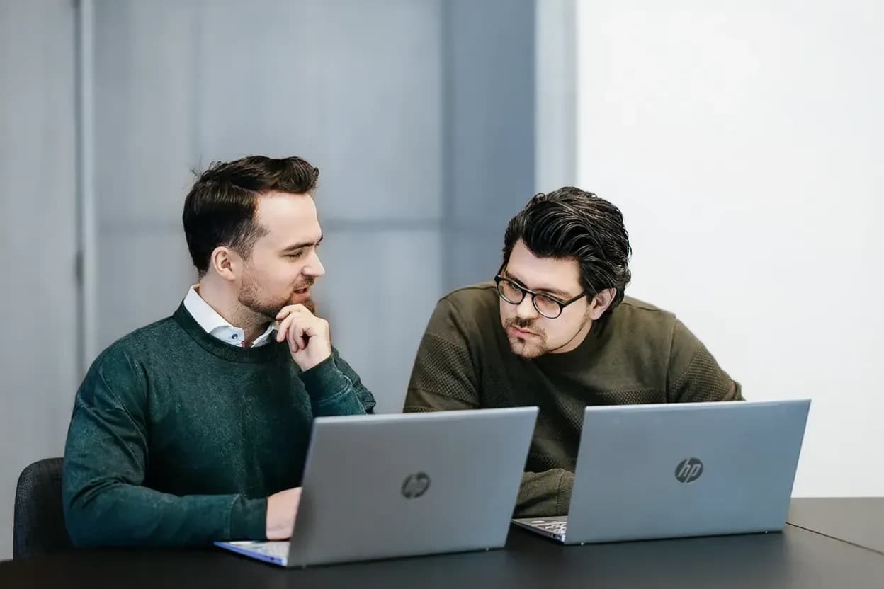 Ontspannen gesprek tussen twee PromptGorillas collega's op de bank met een kop koffie